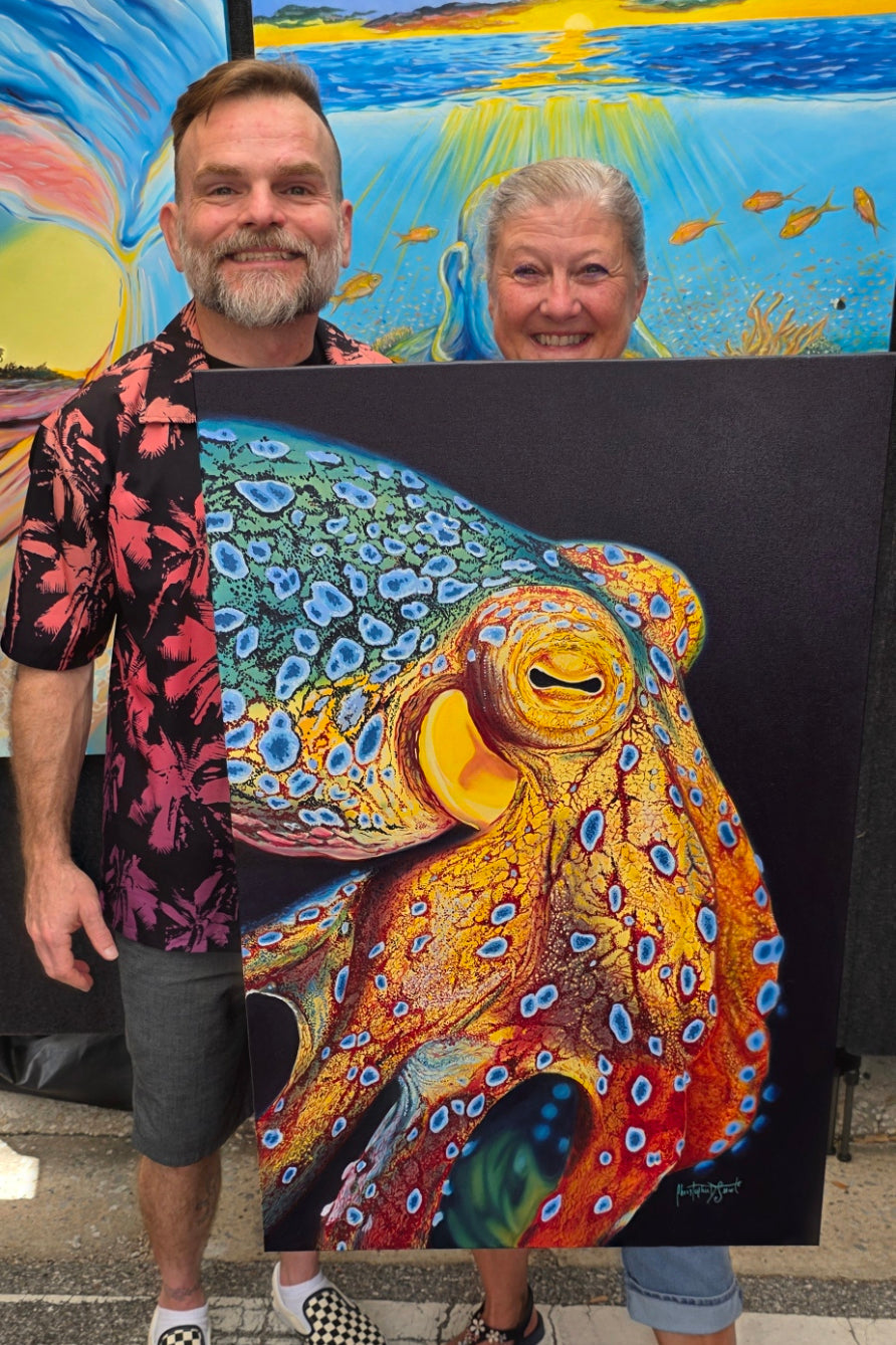 Two people standing next to a large colorful painting of a blue ringed octopus.